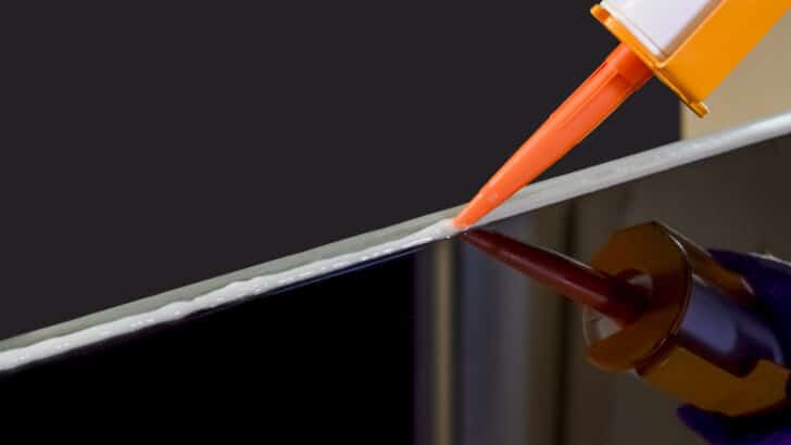 Closeup image of Applying silicone sealant by Caulking gun
